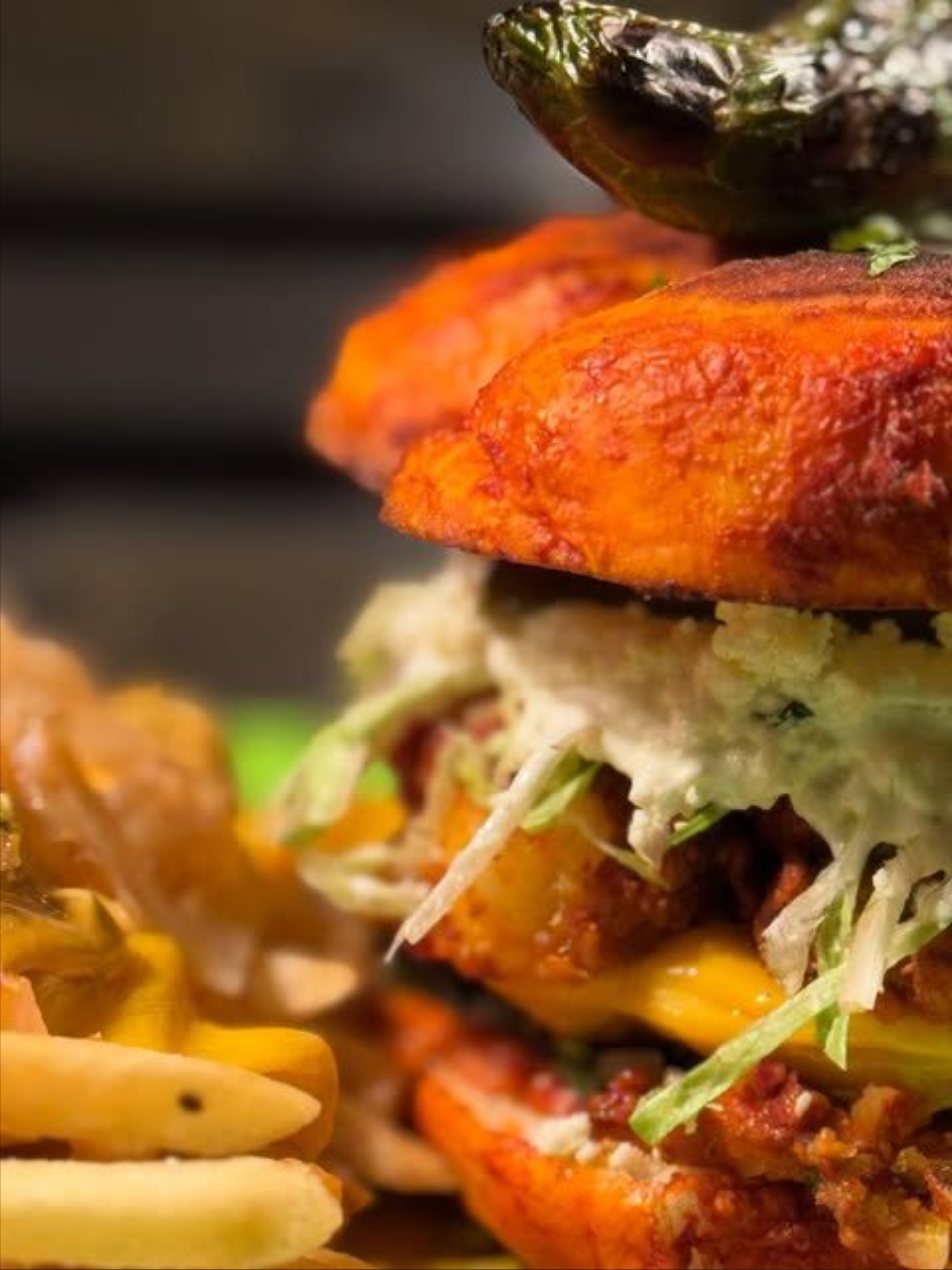 Torta stacked with meat, crema, and a roasted jalapeno, with fries